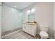 Modern bathroom featuring a glass shower with stone flooring and a white vanity with a granite countertop at 7760 Haven St, Las Vegas, NV 89123