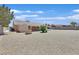 Exterior view of home featuring a large backyard, desert landscaping, and covered patio at 7925 Placid St, Las Vegas, NV 89123