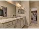 Bathroom featuring dual sinks, granite countertops, and decorative mirror at 7938 Jessamy St, North Las Vegas, NV 89084