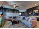 Living room featuring a large sectional sofa, area rug, ceiling fan, and modern decor at 7938 Jessamy St, North Las Vegas, NV 89084