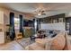 Comfortable living room with a large sectional sofa, ceiling fan, dark accent wall, and tile flooring at 7938 Jessamy St, North Las Vegas, NV 89084