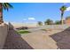 The spacious backyard features palm trees, stone landscaping, and block wall at 7957 Lovely Pine Pl, Las Vegas, NV 89143
