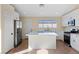 Bright kitchen featuring white cabinets, stainless appliances, and an island with a white countertop at 7957 Lovely Pine Pl, Las Vegas, NV 89143