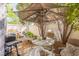 Outdoor patio area with seating, a table, a BBQ grill, and shaded by an umbrella at 7985 Simone Ave, Las Vegas, NV 89147