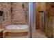 Luxurious bathroom featuring a stone accent wall, soaking tub, and a glass-enclosed shower at 8199 Pinnacle Peak Ave, Las Vegas, NV 89113