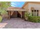 Backyard exterior featuring large, folding glass doors that open onto a brick-paved patio and lush landscaping at 8199 Pinnacle Peak Ave, Las Vegas, NV 89113