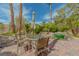 Outdoor patio with table, chairs, umbrella, brick pavers, and lush landscaping with a view of the pool at 8199 Pinnacle Peak Ave, Las Vegas, NV 89113