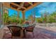 Exterior covered patio featuring an outdoor dining area with pool, spa, and mature landscaping at 8199 Pinnacle Peak Ave, Las Vegas, NV 89113