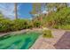 Backyard pool with cool, serene water surrounded by lush greenery and decorative rocks at 8199 Pinnacle Peak Ave, Las Vegas, NV 89113