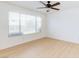 Bright bedroom featuring a ceiling fan, a large window, and light laminate flooring at 8450 Alta Dr # 136, Las Vegas, NV 89145