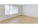 Light-filled bedroom with wood floors, a large window, and white walls at 8450 Alta Dr # 136, Las Vegas, NV 89145