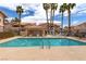 Community pool surrounded by palm trees and lounge chairs at 8450 Alta Dr # 136, Las Vegas, NV 89145