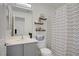 Clean and modern bathroom with vanity storage, decorative shelves, and patterned shower curtain at 9157 Acclamation Ct, Las Vegas, NV 89149
