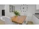 Dining area featuring a wood table, white chairs, and modern wall clock decor at 9157 Acclamation Ct, Las Vegas, NV 89149
