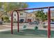 Community playground featuring swings, with residential homes in the background at 9157 Acclamation Ct, Las Vegas, NV 89149