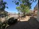 Backyard with wrought iron fence and mature trees, offering privacy and a natural setting at 96 Saint Johns Wood Ave, Henderson, NV 89002