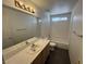 Bathroom features a wooden vanity with a sink, a large mirror, and a shower-tub combo at 96 Saint Johns Wood Ave, Henderson, NV 89002
