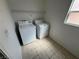 The laundry room features a washer and dryer, tiled floor, and a window for natural light at 96 Saint Johns Wood Ave, Henderson, NV 89002