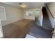 Carpeted living room featuring a staircase, arched doorway, and a window offering natural light at 96 Saint Johns Wood Ave, Henderson, NV 89002