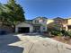 Two-story home with a two-car garage, desert landscaping, and an ample driveway for parking at 9628 Scrub Jay Ct, Las Vegas, NV 89148