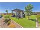 This backyard features a covered patio, artificial lawn, lush landscaping, and is ideal for outdoor living at 10266 Sweet Holly Pl, Las Vegas, NV 89149