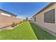 Spacious backyard with easy-to-maintain artificial lawn, rock landscaping, and retaining wall is perfect for relaxing at 10266 Sweet Holly Pl, Las Vegas, NV 89149