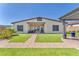Beautiful backyard features manicured landscaping, artificial lawn, and a covered patio with outdoor seating area at 10266 Sweet Holly Pl, Las Vegas, NV 89149