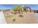 Well-maintained front yard features desert landscaping with mature trees and shrubbery at 10266 Sweet Holly Pl, Las Vegas, NV 89149