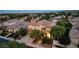 Stunning aerial view of a luxury home in a lush, green neighborhood at twilight at 10729 Grey Havens Ct, Las Vegas, NV 89135