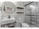 Modern bathroom featuring a floating sink, round mirror, and a patterned glass shower at 10729 Grey Havens Ct, Las Vegas, NV 89135
