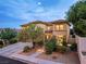 Stately two-story home with a beige exterior, well-manicured landscaping, and a stone driveway at 10729 Grey Havens Ct, Las Vegas, NV 89135
