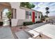 Inviting single story home featuring a red door, desert landscaping, a covered arch, and outdoor seating at 1116 Piazza Telle, Henderson, NV 89052