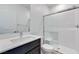 Modern bathroom featuring white countertops, dark cabinets, and a glass-enclosed shower at 1321 Crimson Sunbird Ave, North Las Vegas, NV 89084