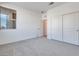 Minimalist bedroom with neutral carpet, double sliding door closet, and bright natural light at 1321 Crimson Sunbird Ave, North Las Vegas, NV 89084