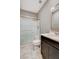 Bathroom with sliding glass shower doors, toilet, dark wood vanity and tiled floor at 139 Fulgora St, Henderson, NV 89074