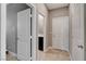 Hallway showing a glimpse into a bathroom, multiple doors, and light colored tiled floors at 139 Fulgora St, Henderson, NV 89074