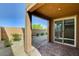 The covered outdoor patio has brick flooring and a view of the rock landscaped yard at 139 Fulgora St, Henderson, NV 89074