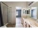 Bathroom featuring double sinks, a shower with glass doors, and an entryway to bedroom at 1838 N Jones Blvd, Las Vegas, NV 89108