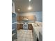Functional kitchen featuring white appliances, tiled countertops and flooring and light wood cabinetry at 1838 N Jones Blvd, Las Vegas, NV 89108