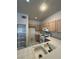 Well-maintained kitchen with tiled countertops, white appliances, tile flooring and light wood cabinets at 1838 N Jones Blvd, Las Vegas, NV 89108