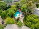 Aerial view of a backyard with a pool, hot tub, stone patio, mature trees, and lush landscaping at 1925 Grey Eagle St, Henderson, NV 89074