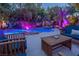 Backyard pool and patio featuring lush landscaping and comfortable outdoor seating and table at 1925 Grey Eagle St, Henderson, NV 89074