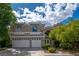 Charming two-story home featuring a three-car garage, arched windows, and lush landscaping at 1925 Grey Eagle St, Henderson, NV 89074