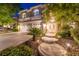 A charming two-story home exterior at night with illuminated landscaping and elegant double-door entrance at 1925 Grey Eagle St, Henderson, NV 89074