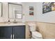 Neat half bathroom featuring a blue vanity, white toilet, and a decorative mirror, offering a clean and functional space at 1925 Grey Eagle St, Henderson, NV 89074