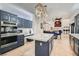 Spacious kitchen with a center island, modern appliances, custom cabinets, and stylish light fixtures at 1925 Grey Eagle St, Henderson, NV 89074