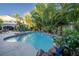 In-ground pool with rock accents, lush landscaping, and mature trees surrounding the pool deck and patio area at 1925 Grey Eagle St, Henderson, NV 89074