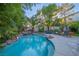 Backyard pool area featuring lush landscaping, trees, and comfortable outdoor seating at 1925 Grey Eagle St, Henderson, NV 89074