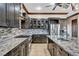 Modern kitchen featuring gray cabinets, granite countertops, stainless steel appliances, and stone backsplash at 2051 Saginaw Ave, Pahrump, NV 89048