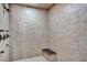 Tiled shower features bronze fixtures, a rainfall shower head, and a built-in bench for comfortable bathing at 2051 Saginaw Ave, Pahrump, NV 89048